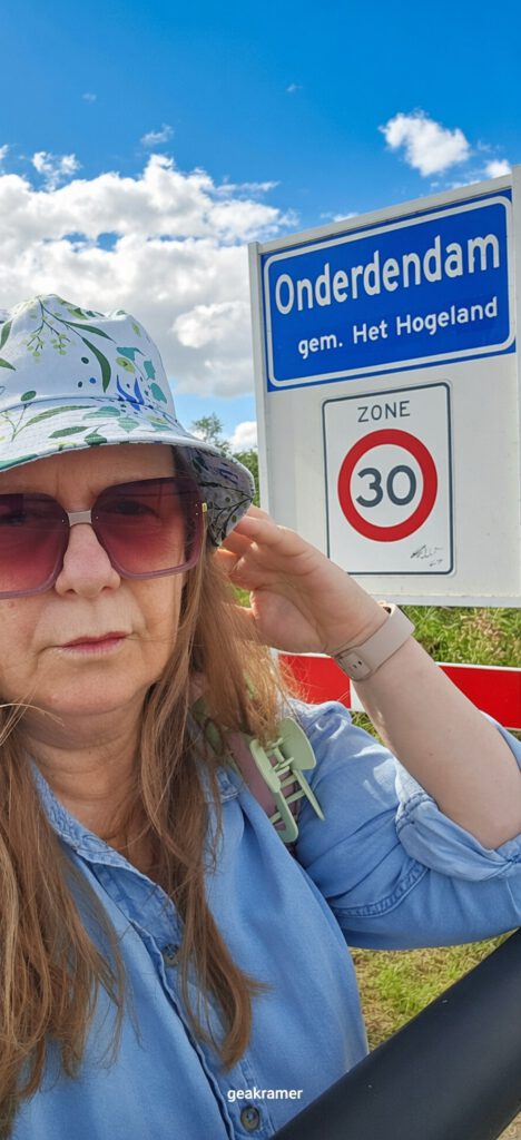Gea Kramer Groningen bij het plaatsnaambord van Onderdendam in gemeente Het Hogeland