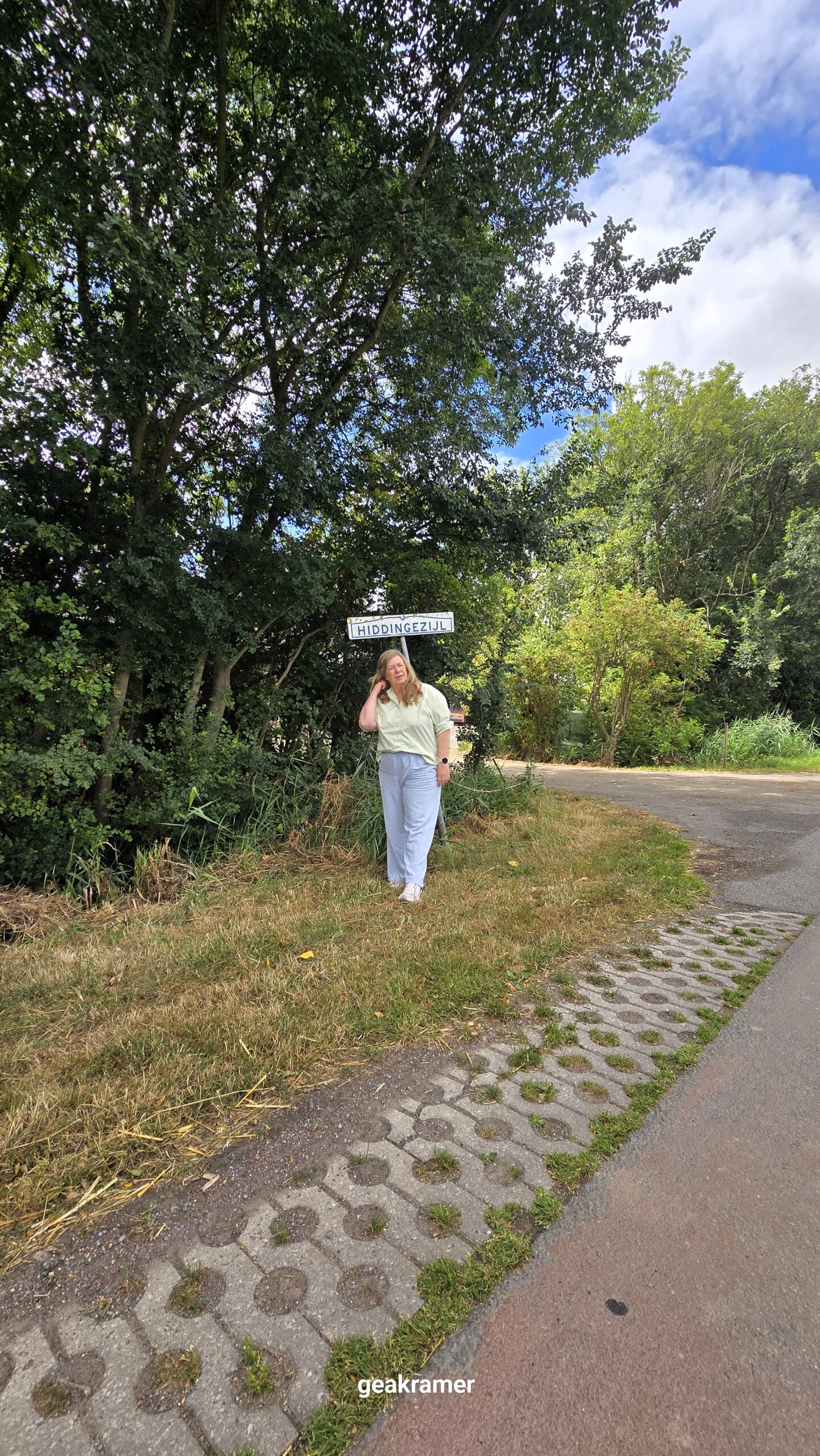 Gea Kramer bij het plaatsnaambord Hiddingezijl op het Hogeland
