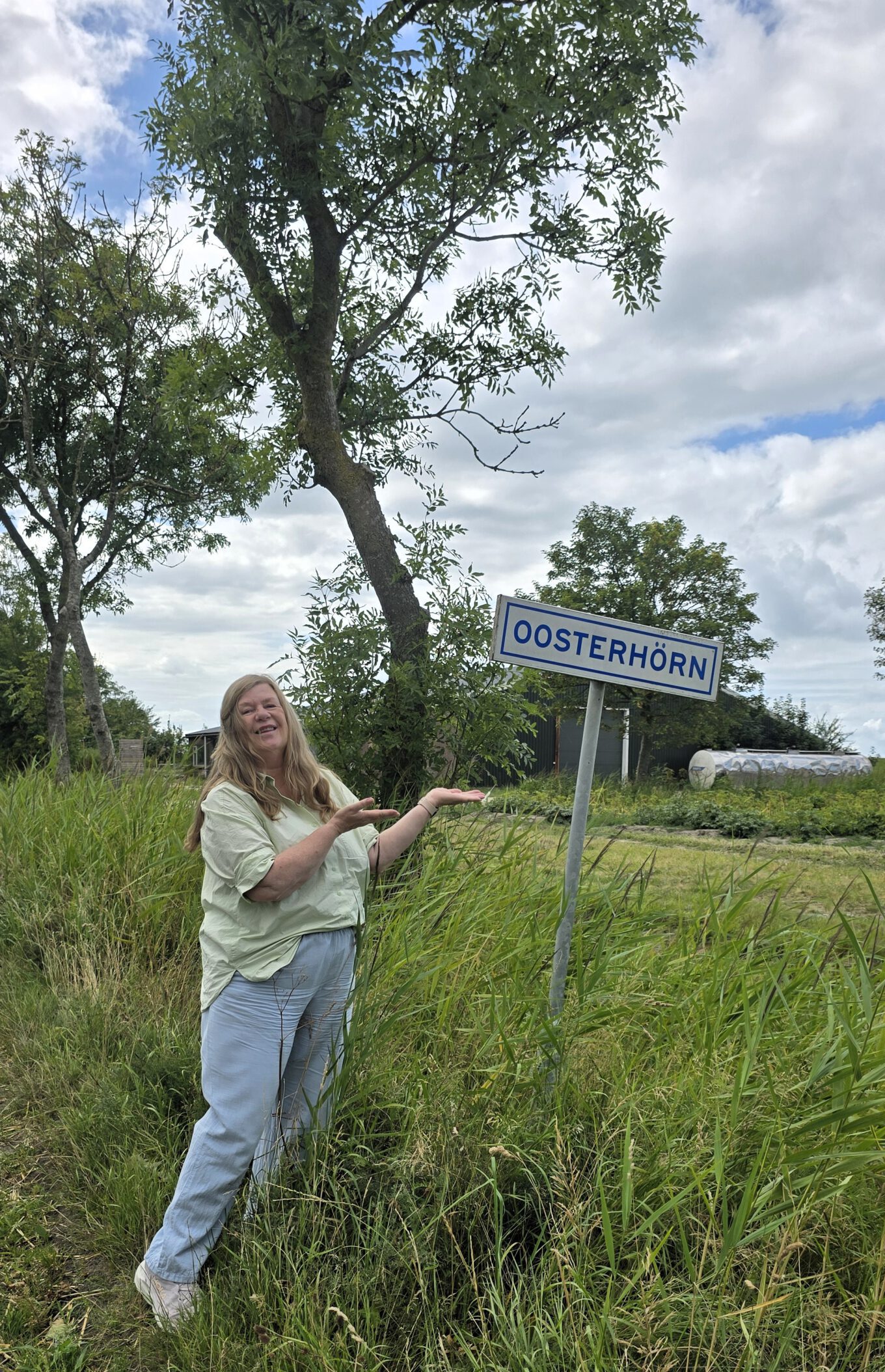 Gea Kramer bij het plaatsnaambord Oosterhörn op het Hogeland