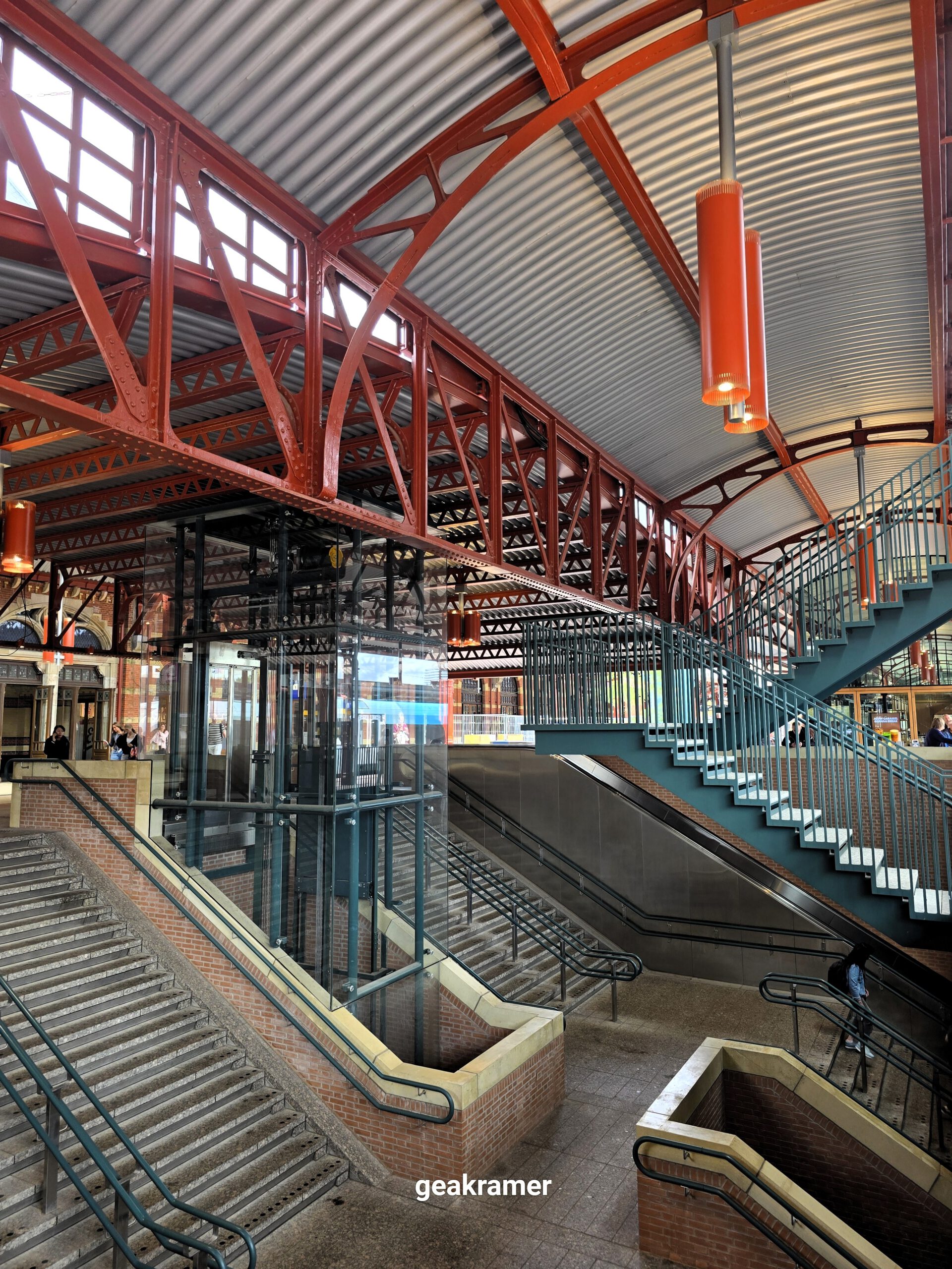 Interieur van Groningen Hoofdstation met de kenmerkende rode staalconstructie – Gea Kramer